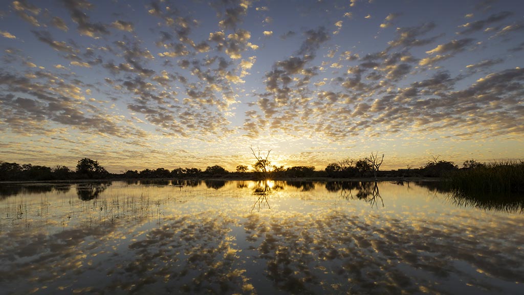 A spectacular sunrise at Muloorina Station reflected in the water just to the north of Marree, South Australia