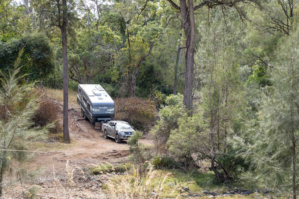 4wd towing caravan down into a steep gully